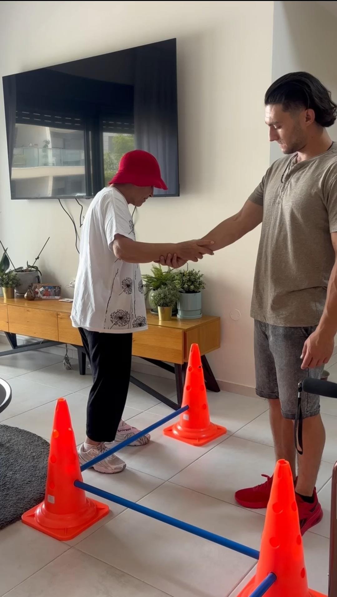 עידן מלווה מטופלת בתרגול תנועה בבית